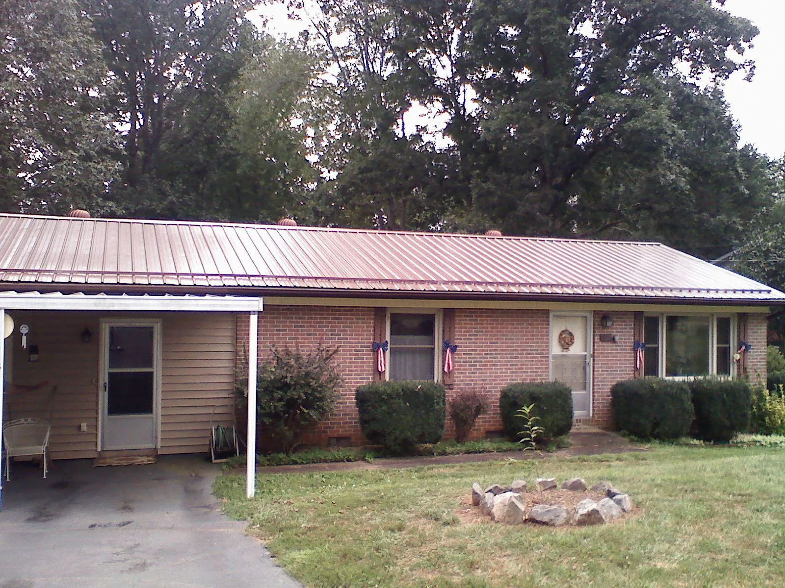 Bronze metal roof and carport on a brick ranch home — Roof Repair work by our crew in Mastic Beach